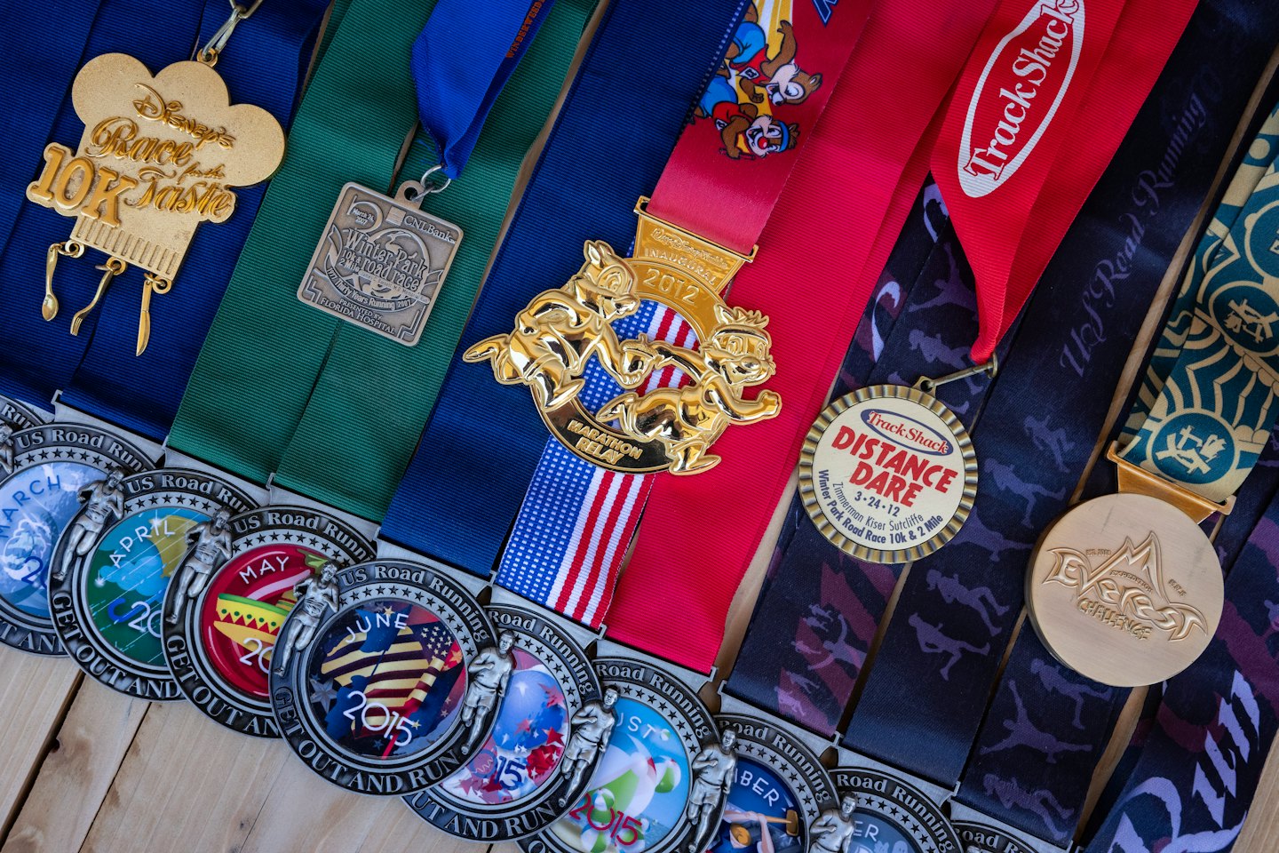 Medallas de maratón y de carrera sobre una superficie de madera.